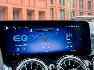 Närbild av Mercedes navigationsskärm med EQ-logga och telefonfunktion.
