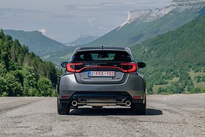 Toyota GR Yaris sedd bakifrån på en landsväg med berg i bakgrunden.