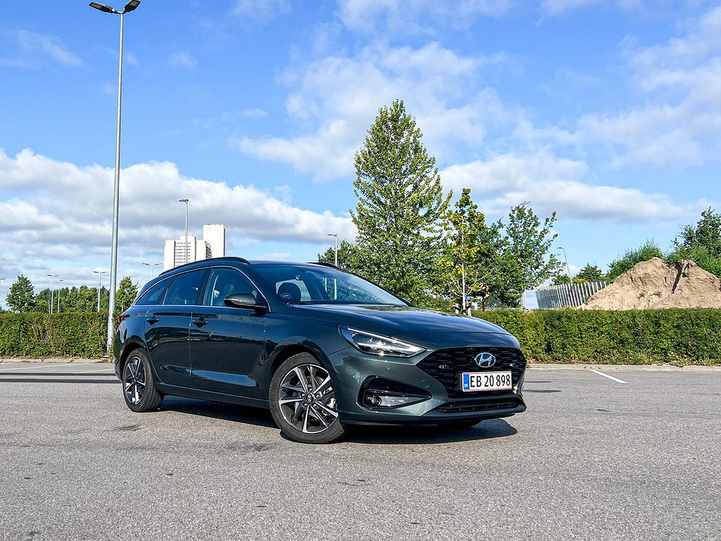 Grön Hyundai i30 parkerad på en öppen yta, fotograferad i trekvartsvy från fronten.