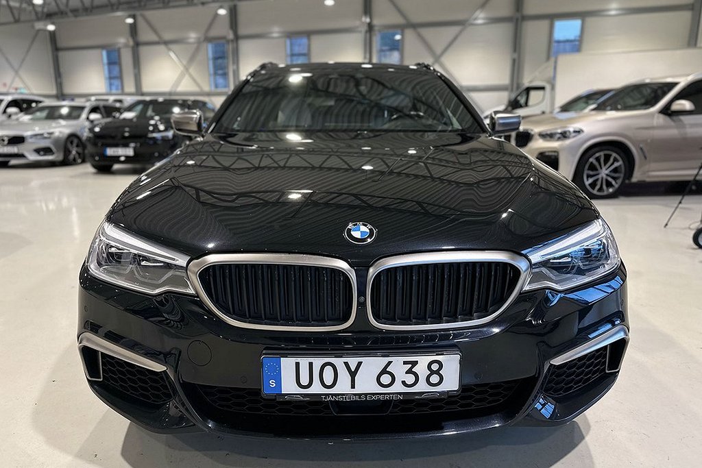 Närbild på fronten av en svart BMW, med märkets karakteristiska grill i fokus.