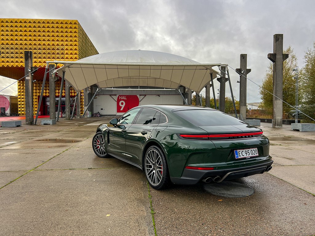 Grön Porsche Panamera sedd snett bakufrån, parkerad på betong.