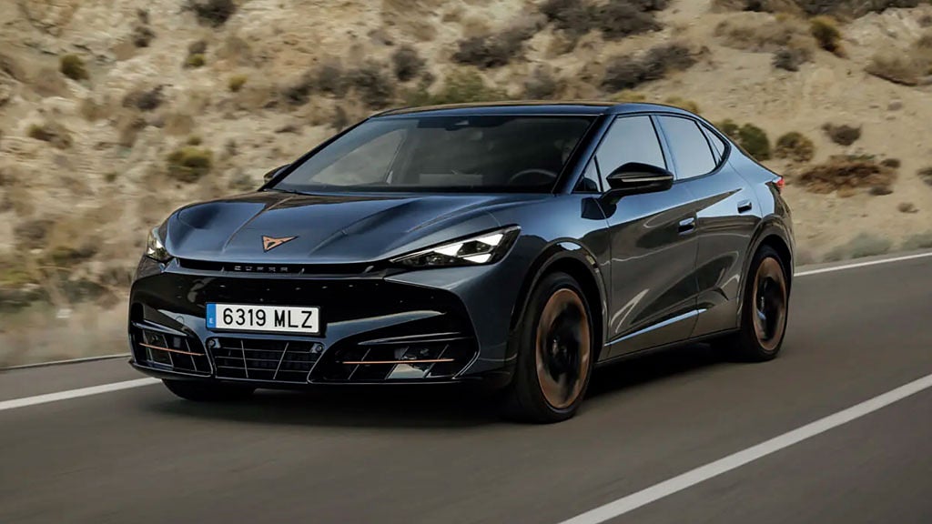 Svart Cupra kör på en landsväg i ett torrt landskap.