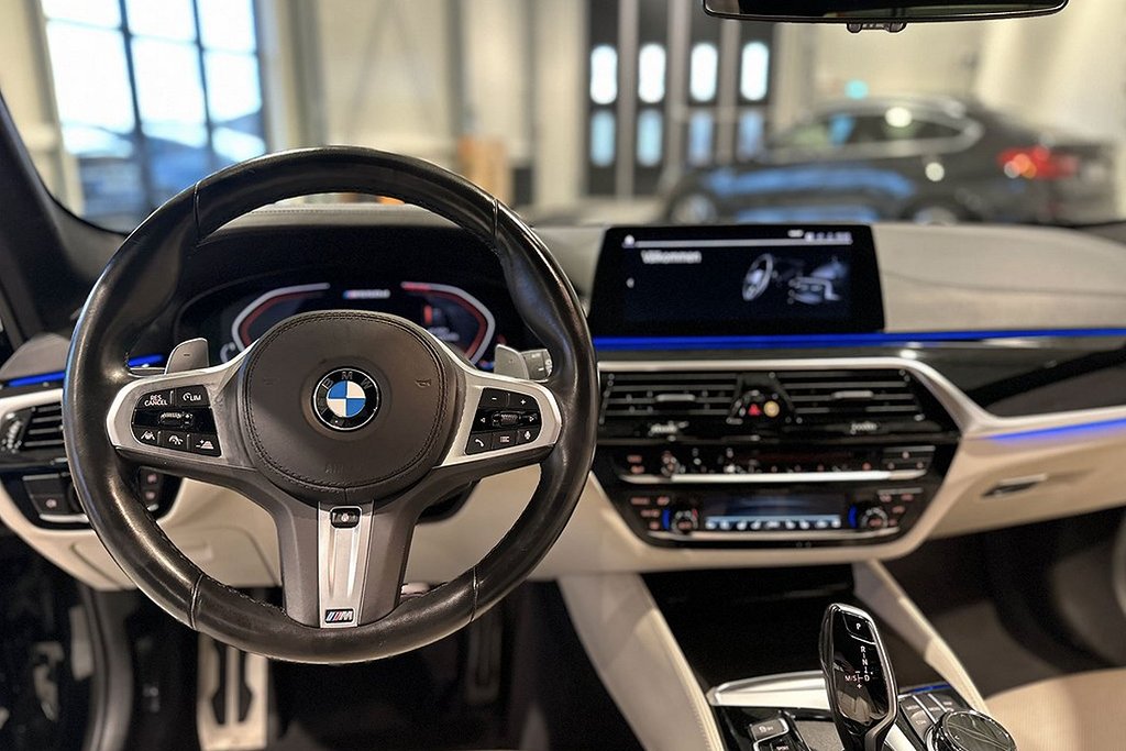 örarplats med BMW ratt och infotainmentsystem på instrumentpanelen.