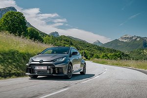 Toyota GR Yaris kör på en landsväg med berg i bakgrunden.