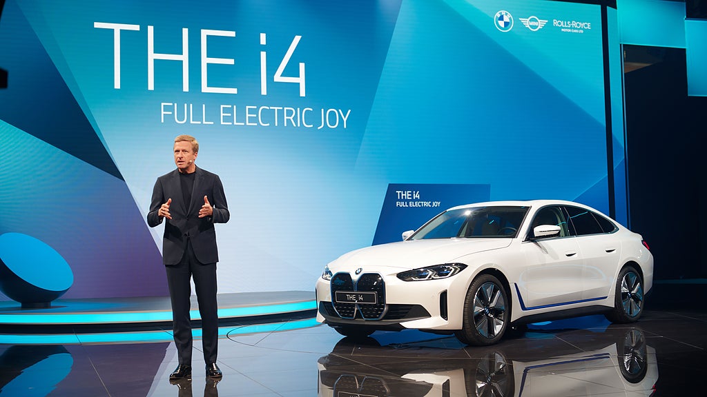 Oliver Zipse står snett framför nya BMW i4