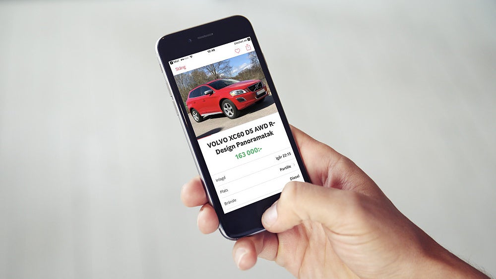 Person håller i mobiltelefon som visar en begagnad Volvo XC60 på Blocket